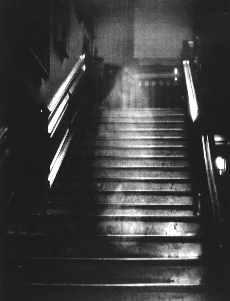 black and white photograph of an escalator with light coming from the top down