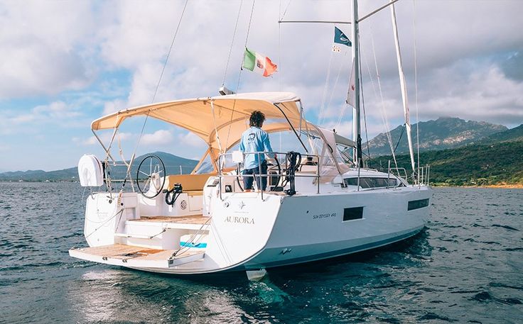 a man standing on the bow of a sailboat