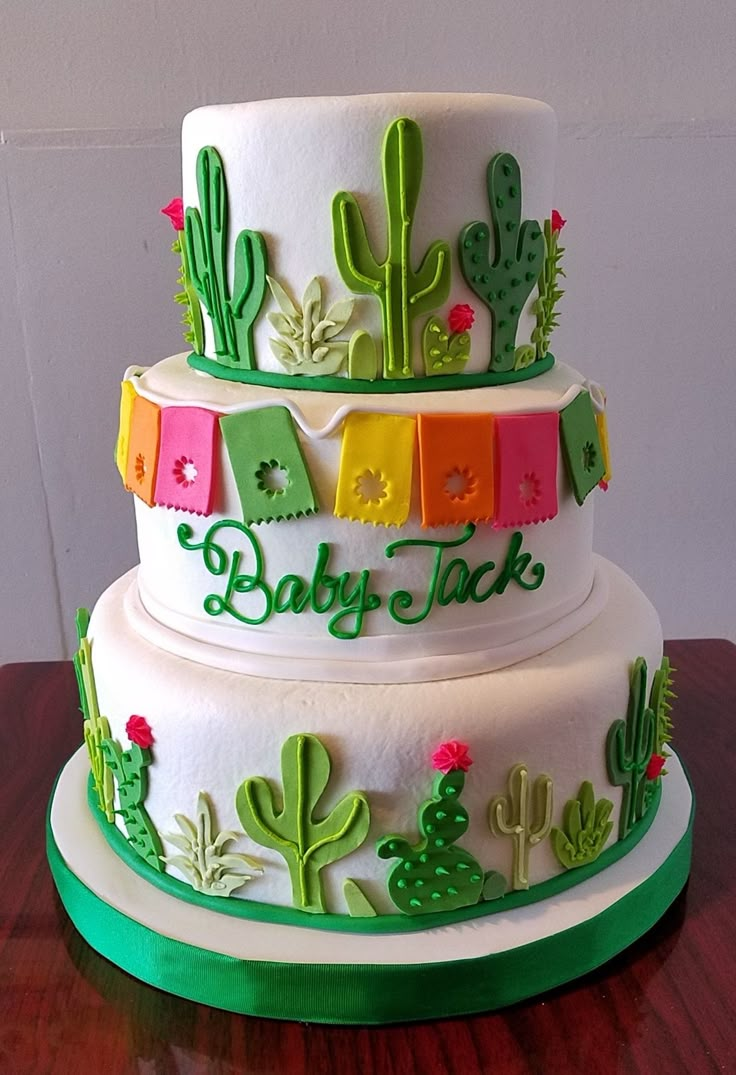 a three tiered cake with cactus decorations on the side and name baby dixie on top