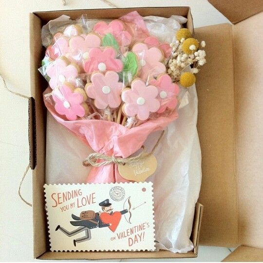 an open box with some pink flowers in it