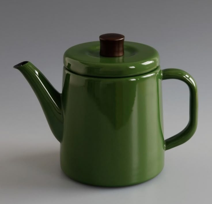 a green teapot with a wooden top on a gray background, it is empty