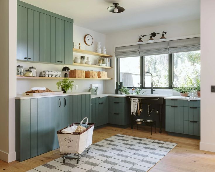 a kitchen filled with lots of green cabinets and counter top space next to a window