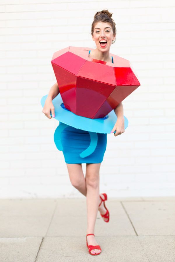 a woman is walking down the street with a large object on her head and legs