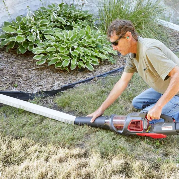 a man laying on the ground with a power tool