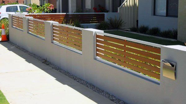 a white fence with wooden slats on the top and bottom, in front of a house