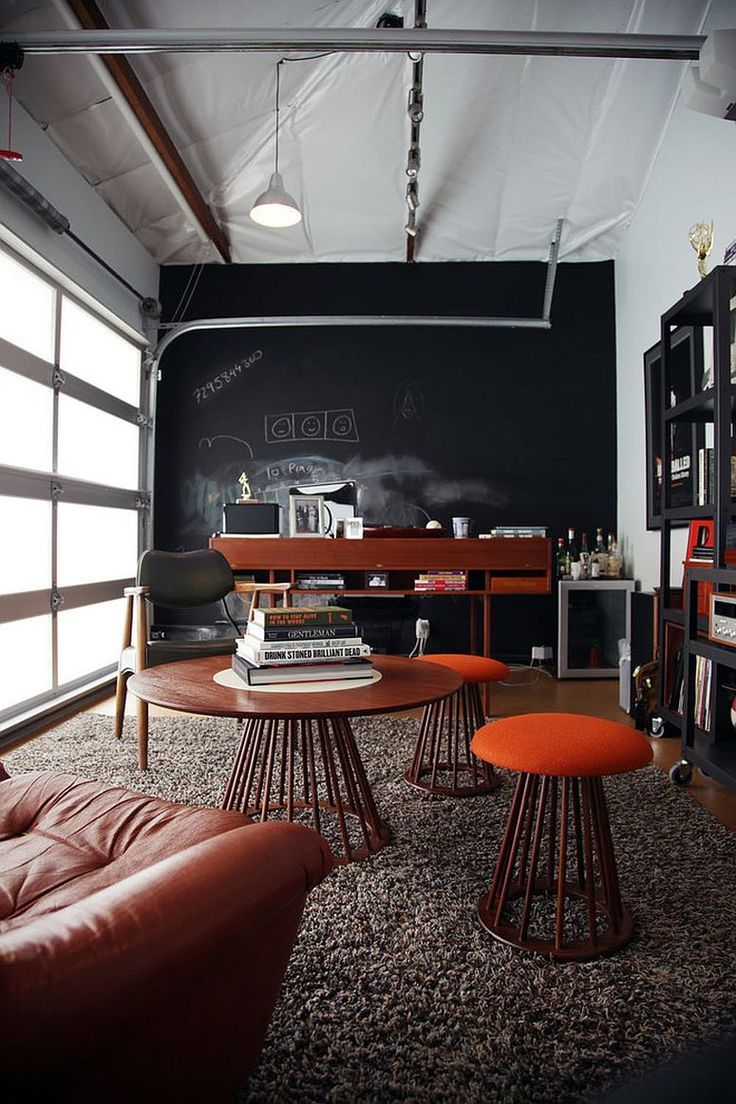 a living room filled with furniture and a chalkboard wall