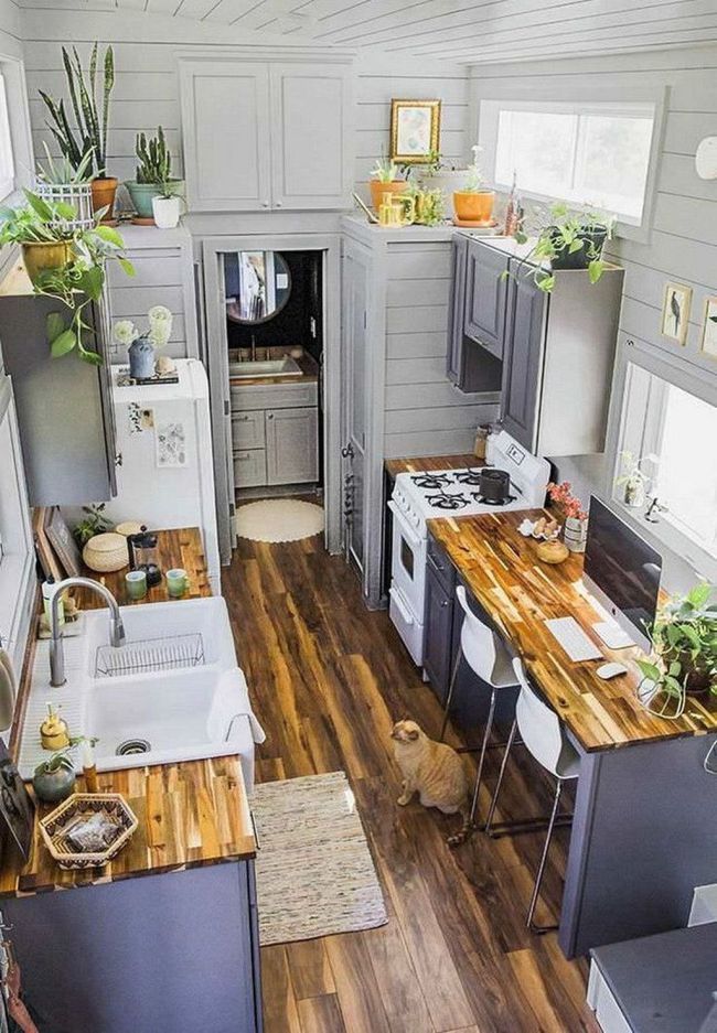 an aerial view of a kitchen and dining area with wood floors, white walls and gray cabinets