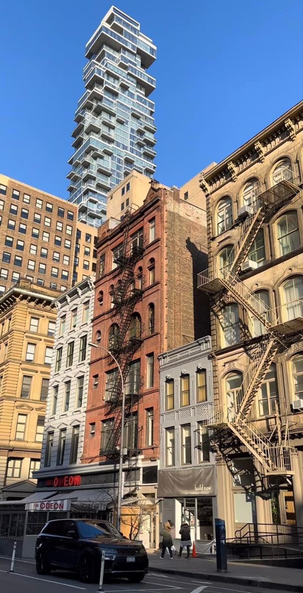 the tall building has many windows and balconies on it's sides, along with other buildings