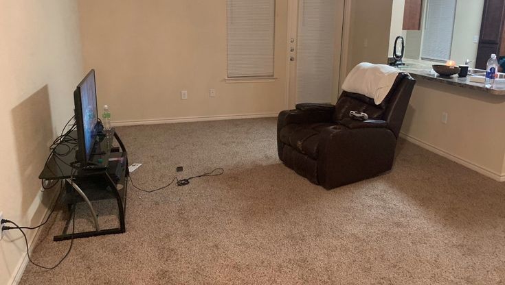 a living room with a chair and television in it