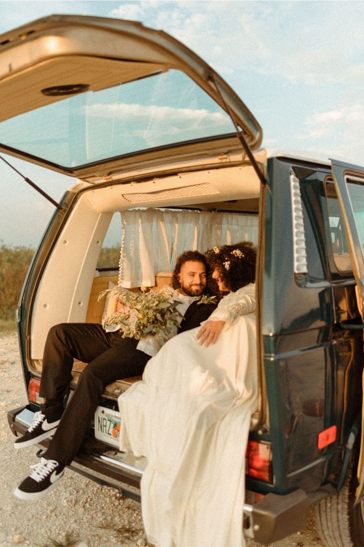 a man and woman sitting in the back of a van