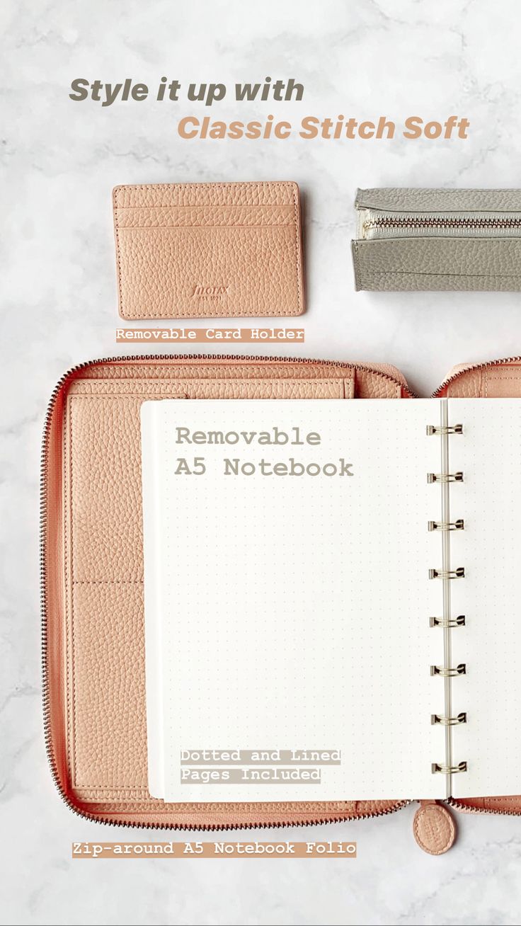 an open notebook sitting on top of a table next to a pencil case and coin