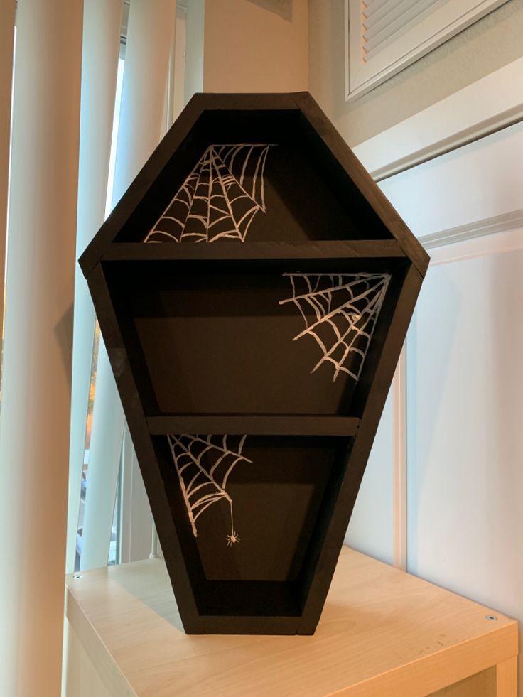 a black shelf with spider webs on it