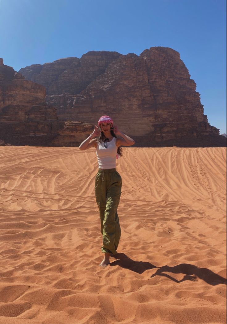 a woman standing in the middle of a desert