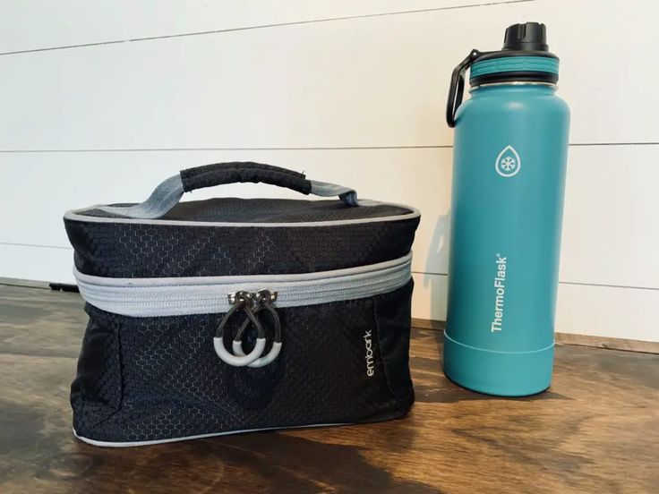 a water bottle and lunch bag sitting on a table