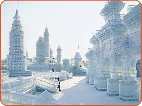 a person standing in the middle of an ice city with tall buildings behind them and snow on the ground