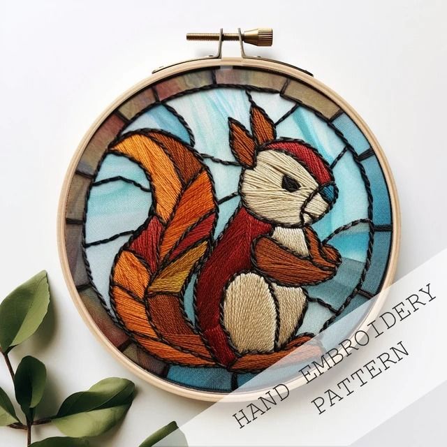 a hand embroidered squirrel sitting in front of a stained glass window with leaves around it