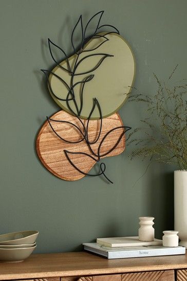 a wooden table topped with a vase filled with flowers next to a wall mounted mirror