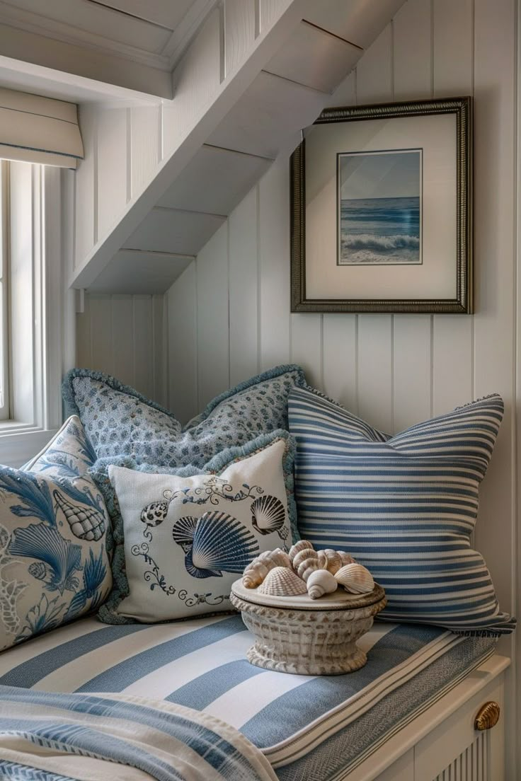 a basket filled with seashells on top of a bench next to a window