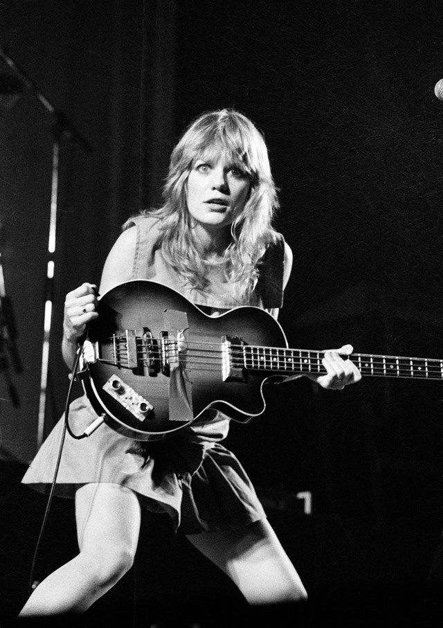 a woman playing an electric guitar on stage