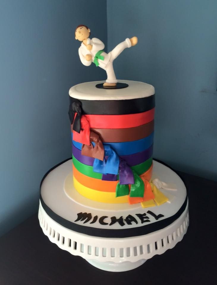 a multicolored cake with a person doing karate on top and the words michael above it