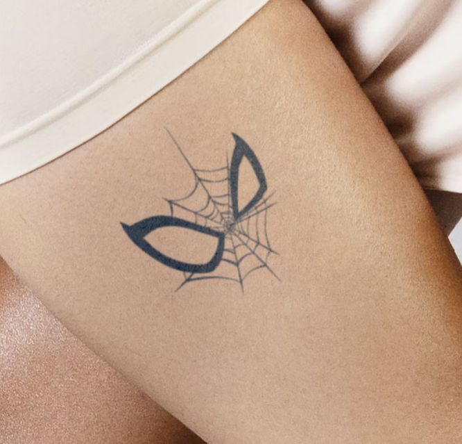 a woman with a spider web tattoo on her thigh