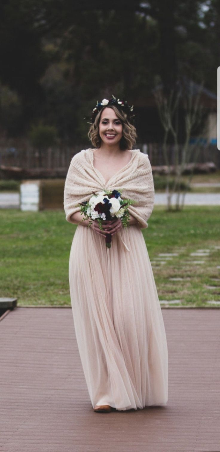 a woman in a long dress holding a bouquet