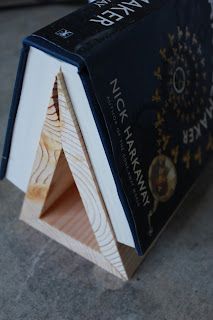 an open book sitting on top of a wooden block