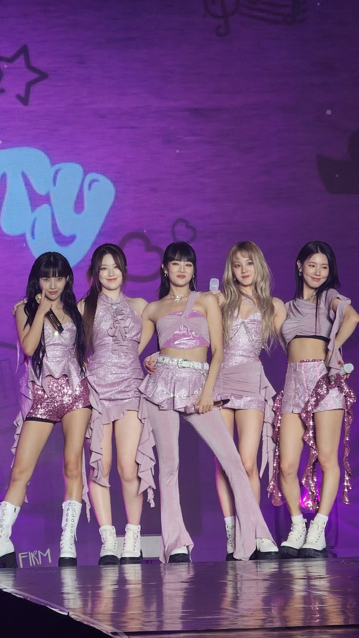 girls'generation performing on stage at an event with purple lighting and stars in the background