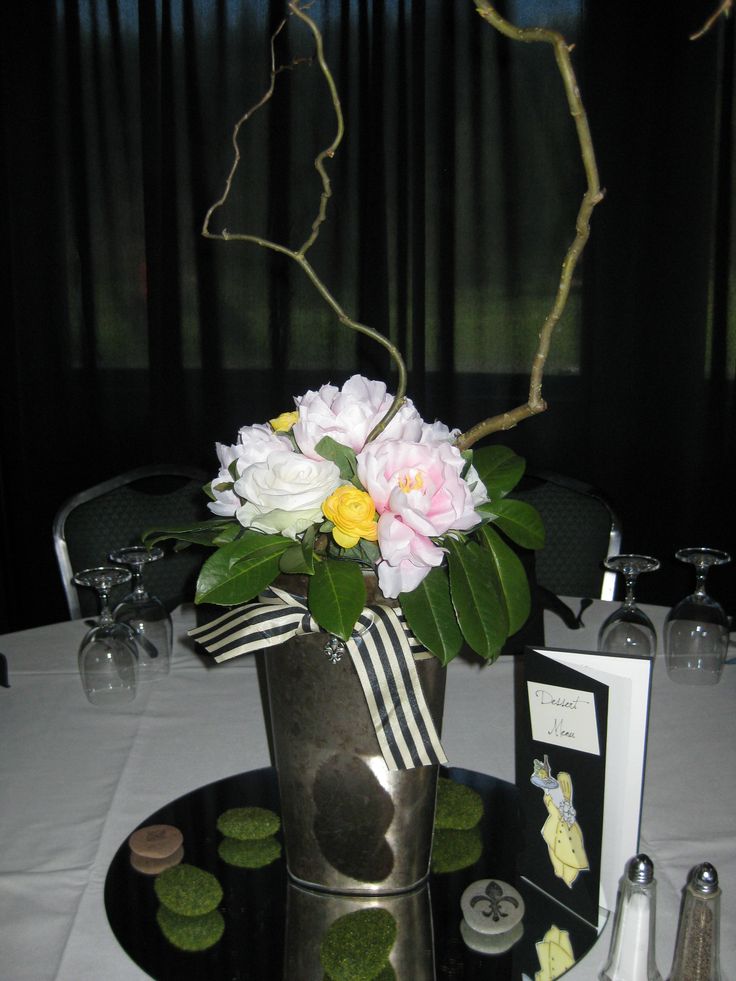 there is a vase with flowers in it on top of a black and white table