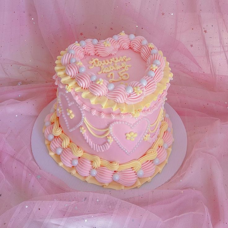 a pink and yellow birthday cake on a plate