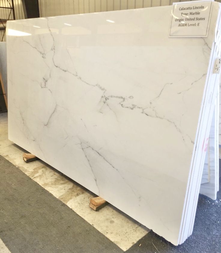 a large white marble slab is on display in a store, with the price tag above it