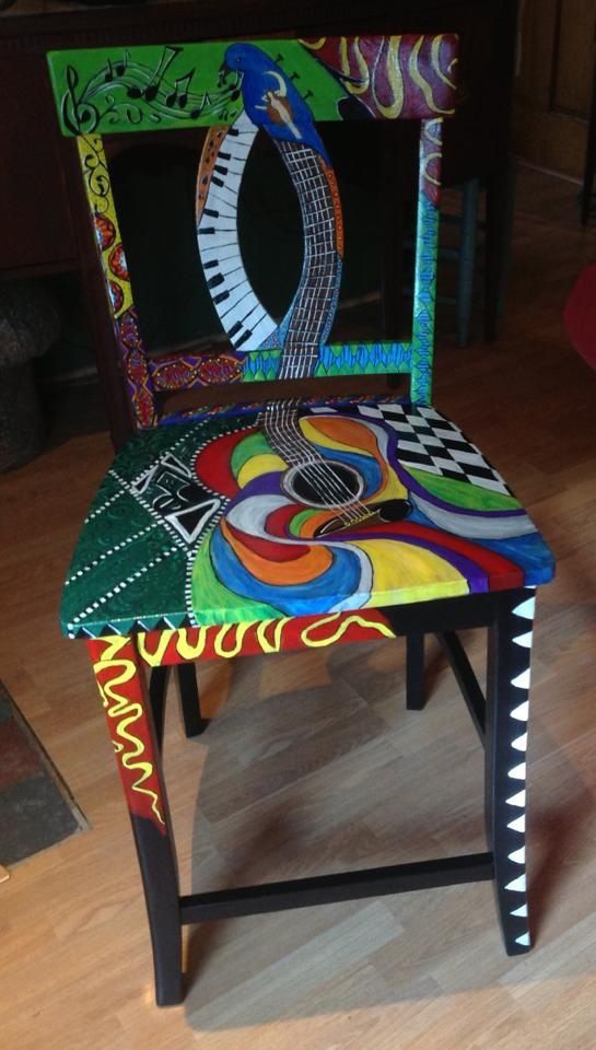 a colorful painted chair sitting on top of a hard wood floor