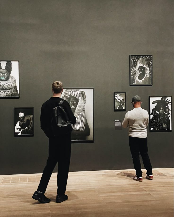 two people looking at art on display in a museum