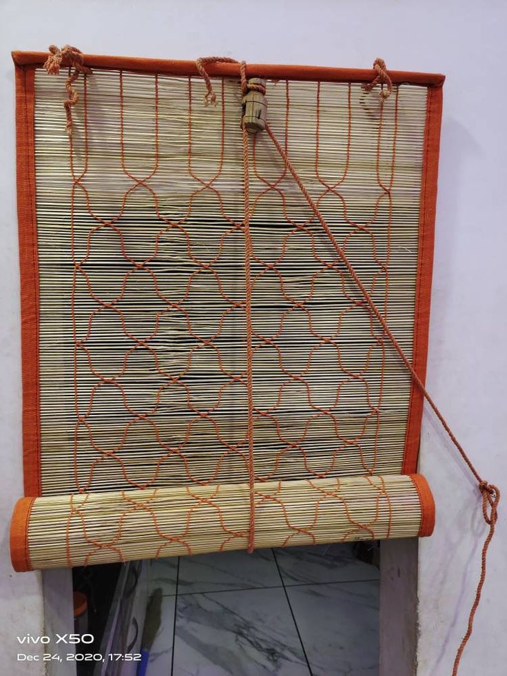 a close up of a bamboo window covering with orange lines on the bottom and sides