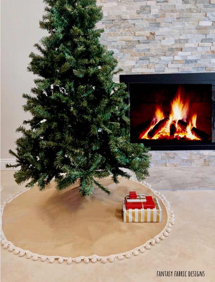 a small christmas tree sitting on top of a rug next to a fire place in a fireplace