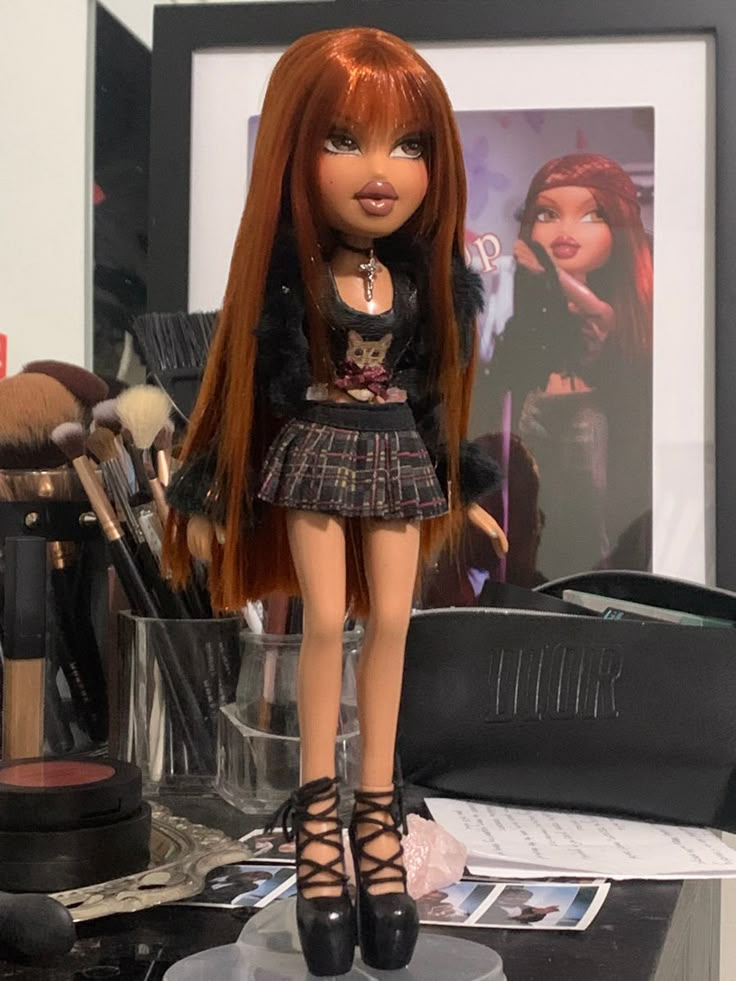 a doll with red hair is standing on a desk