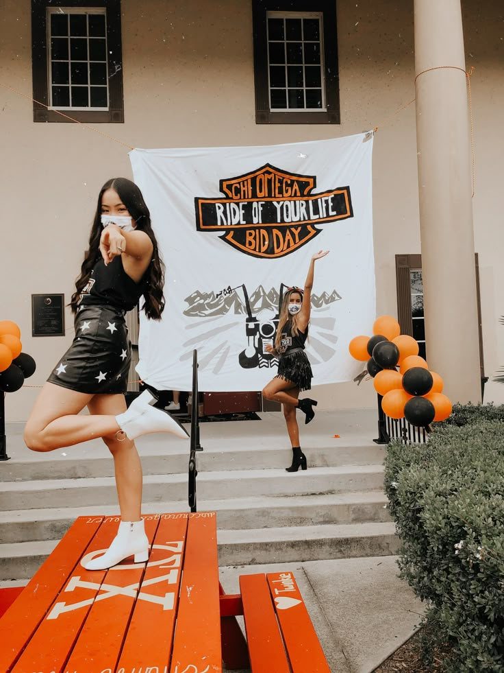 two young women are dancing in front of a sign