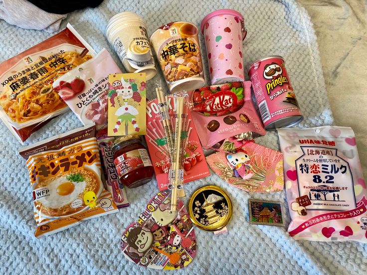 various snacks and drinks are laid out on a bed