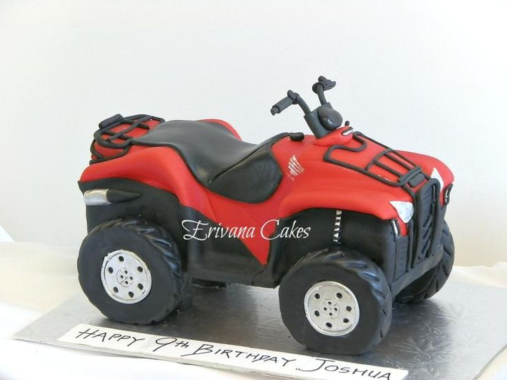 a red and black birthday cake with a toy atv on it's front wheel