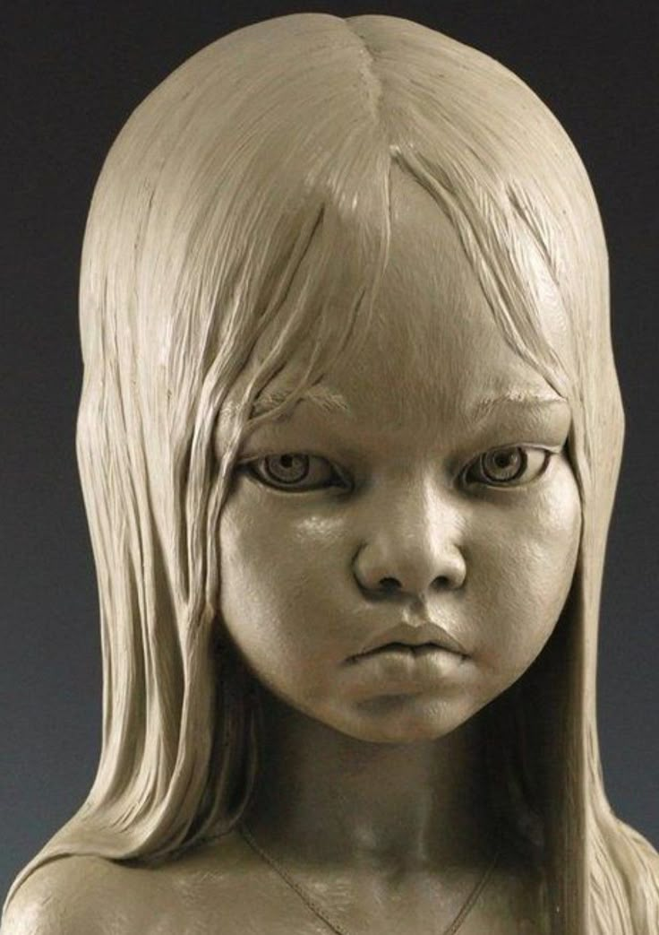 a close up of a statue of a girl with long blonde hair and big eyes