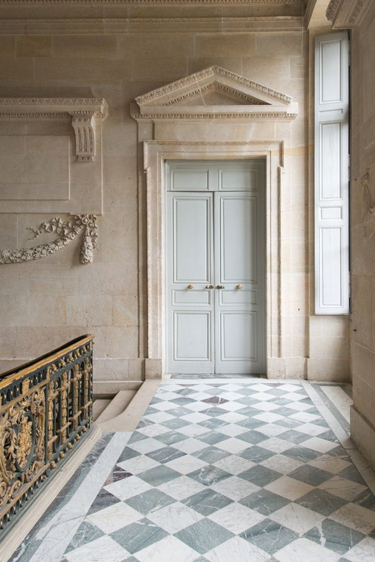 the entrance to a building with an ornate door and checkered floor