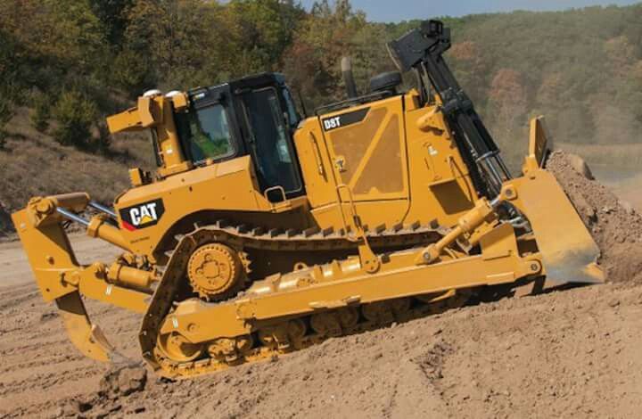 a large yellow bulldozer digging through the dirt