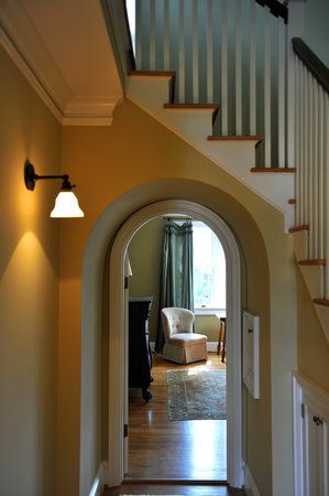 an archway leading to a living room and dining room in a house with wood floors