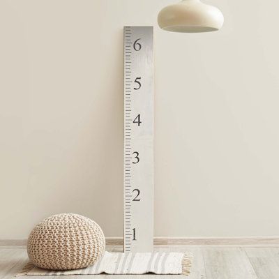 a white floor lamp next to a ruler