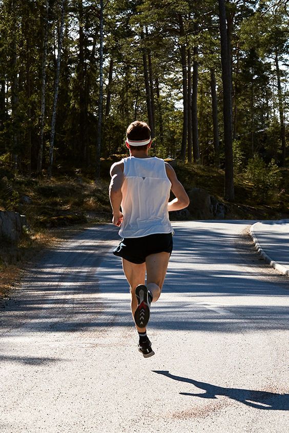 a man running down the road in shorts