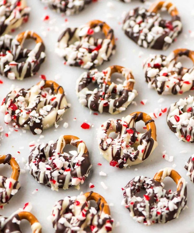 chocolate covered pretzels with white and red sprinkles on a baking sheet