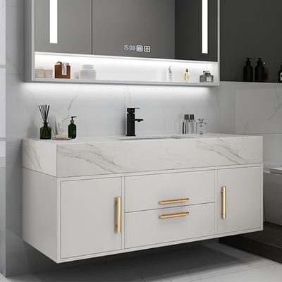 a modern bathroom with marble counter tops and gold pulls on the cabinet doors, along with an illuminated mirror above the sink