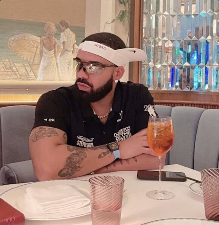 a man sitting at a table with a drink in front of him