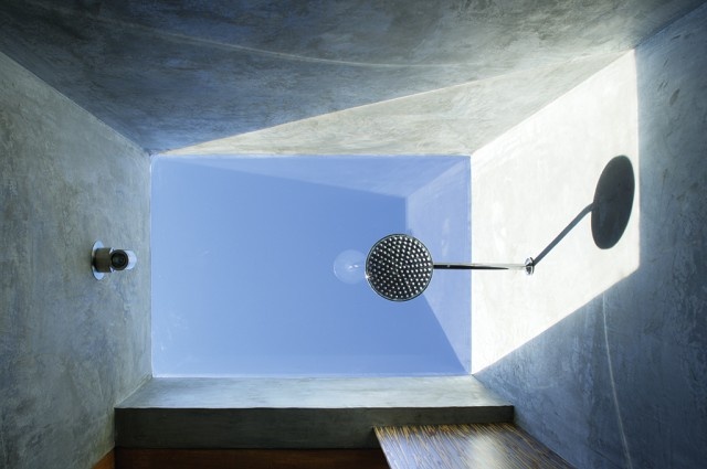 a room with a window and a light fixture on the ceiling in front of it