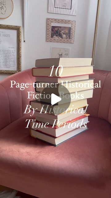 a stack of books sitting on top of a pink couch